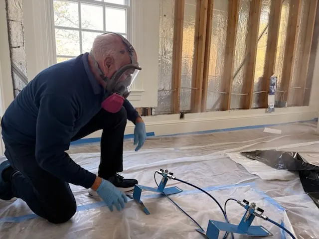 A restoration technician setting drying equipment in an Apopka home stripped to the studs